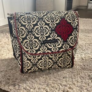 Designer diaper bag with diaper changing pad and backpack straps.